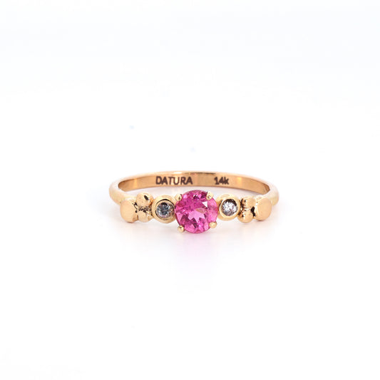Gold ring with a pink gemstone and diamonds on a white background