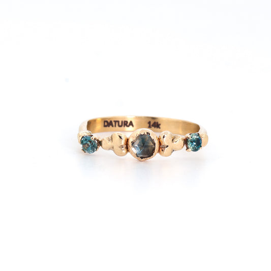 Gold ring with blue gemstones on a white background